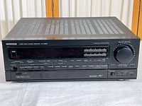 Front view of the Kenwood KR-V8020 audio video stereo receiver showing power button, multiple function buttons, digital display and volume knob.