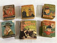Photo showing all six vintage 1930s Whitman 'Big Little Books' arranged in two rows. Titles visible: Tarzan of the Apes, Dick Tracy Out West, Dick Tracy Nova Scotia, Jackie Cooper Skippy & Sooky, Tom Beatty Age of the Service, Moon Mullins Kayo.