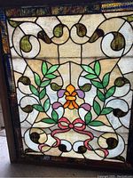 Full front view of stained glass panel showing overall design and wood frame