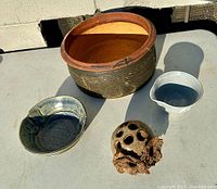 Overview of all four pottery items on table in sunlight, showing the different shapes, colors, and surface textures