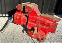 Side view of the red Craftsman bench vise showing the solid cast body, handle, and jaws.