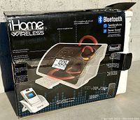 Front of original box showing iHome Wireless alarm clock with MP3 dock, featuring Bluetooth speakerphone and stereo sound.