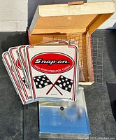 Multiple Snap-On metal logo panels, cooking grids, and portable BBQ unit outside the box