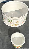 Two porcelain bowls, one large Wedgwood with strawberry decoration and one smaller Portmeirion with flower and insect prints.