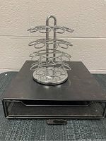 Two silver swivel metal K-Cup holders shown with circular bases and multiple oval slots for cups.