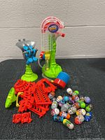 Full view of the Mighty Beanz lot showing 25 collectible Beanz, red accessory parts, blue and red launcher and two playsets with bases.