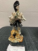 Front view of the ceramic bread seller figurine showing full figure and base detail.