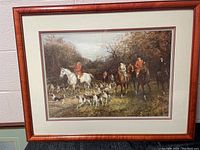 Full view of the framed print showing a detailed outdoor scene with riders in red coats and a pack of foxhounds.