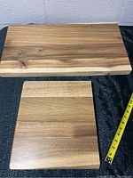 Two wood blocks laid on a black fabric surface. Larger block is approx 23 x 12.5 x 1.5 inches, smaller block approx 11 x 12 x 1.5 inches.