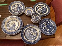 Collection of assorted Blue Willow patterned plates and fruit nappies arranged on a table.