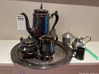 Full tea set on display showing teapot, tray, cream and sugar set, small jug, and sugar container