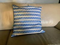 Front view of square pillow with blue and white striped geometric pattern cover