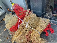 Photo showing bundled wireframe pieces of the reindeer and sleigh with LED lights visible, tied with ribbons.