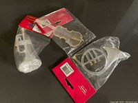 Photo showing three musical instrument Christmas ornaments in original packaging: trumpet, violin, and French horn.