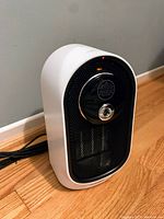 Image showing the small ceramic heater and humidifier unit in white and black color with circular control on front.