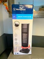 Front view of the boxed Westinghouse ceramic tower heater with product features and image of the heater on front of box.