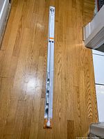 Full length view of the white curtain rod in packaging showing item and length