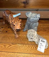 Three animal figurines on a wooden surface: leopard, pig, and dog, showing overall lot contents and condition.