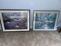 Both framed floral landscape prints shown side by side on the floor against a wall.