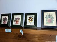 Four framed floral prints displayed in a row showing general set and frame styles.