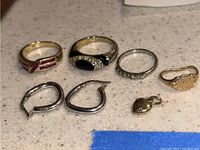 Overview of four rings, heart pendant and two hoop earrings