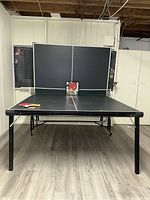 Full front view of assembled table with net attached and paddle set on surface