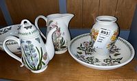All four pieces displayed together on wooden shelf: coffee pot, pitcher, serving bowl and vase