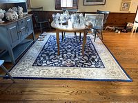 Full view of the Kenneth Mink rug laid on wood floor with table and chairs on top.