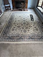 Full view of the rectangular handwoven rug spread in a room showing its overall design and size.
