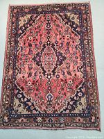 Full view of hand-knotted wool rug showing central medallion and border pattern