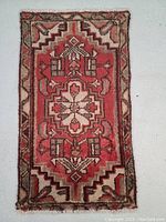 Full area view of small Persian rug with central medallion and border geometric design in traditional colors.