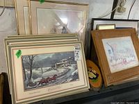 Currier & Ives winter scene prints arranged in stack featuring horse racing scene framed under glass with cream matte borders.