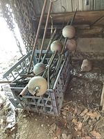 Crate containing multiple copper rods with spherical insulators and pointed tips, straight pipes, and decorative planter