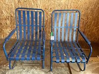 Pair of blue metal rocking chairs, showing full front view and rocker legs for both chairs.