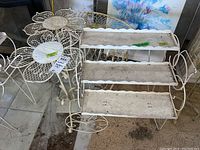 Group view of petal‐motif round table, small round table beneath, three‐tier stand and oval mesh table