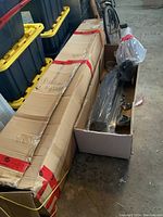 Boxed and bagged components including frame parts and fabric for a 10x12 sun shelter tent.