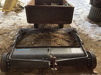 Front view of tow-behind sweeper housing and wheels