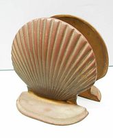 Side view of a single brass scallop shell bookend showing brass material and base