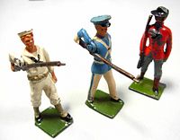Three vintage Britains metal toy soldiers posed together on white background, showing colorful painted uniforms and rifles.