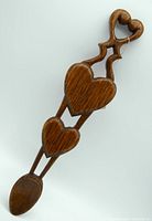 Front view of the wooden Welsh love spoon showing three carved hearts along the handle and open double hearts at top.