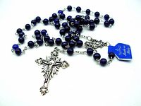 Blue bead rosary laid out showing full length with cross pendant and blue tag.