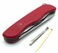 Closed view of red Victorinox Swiss Army pocket knife lying flat with tweezers and toothpick alongside showing logo on handle.
