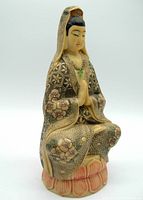 Front view of vintage Guanyin statue seated on lotus base with hands together in prayer, detailing floral and patterned robes.