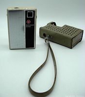 Westinghouse CR-560 vintage portable radio next to its carrying case with wrist strap, showing overall size and condition.