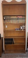 Full bookshelf front view showing five shelves with staged books for size reference.