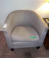 Front view of grey tub armchair showing cushion and fabric texture.