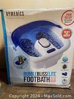 Front of the box showing the HoMedics Bubble Bliss Elite Foot Bath Spa product in purple and white with features highlighted.