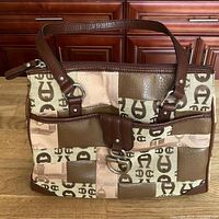 Front view of the vintage Etienne Aigner shoulder bag showing logo patchwork, leather straps, and front clasp.