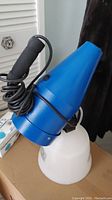 Blue and white Clean Vac fogger device with black handle and cord.