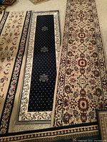 Photo of four acrylic area runners laid out on a carpeted floor, showing full length and design details.